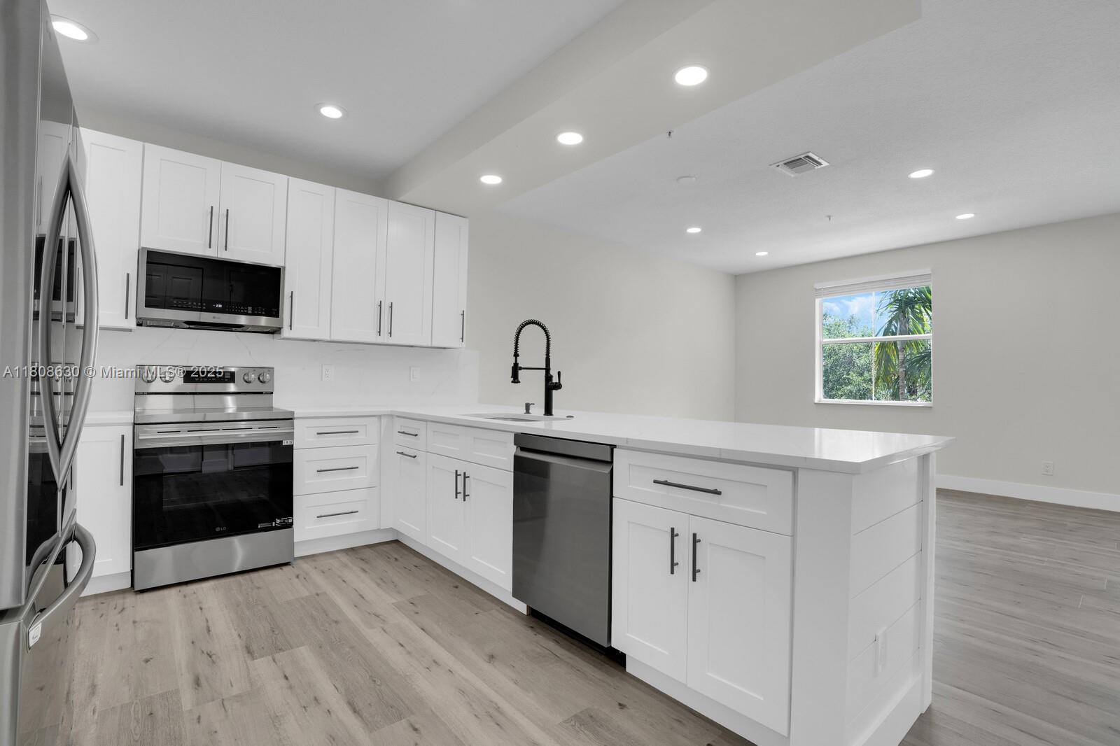 4123 Parkside Drive Jupiter, FL 33458 - Photo 3 of 39 a kitchen with a sink stove and microwave