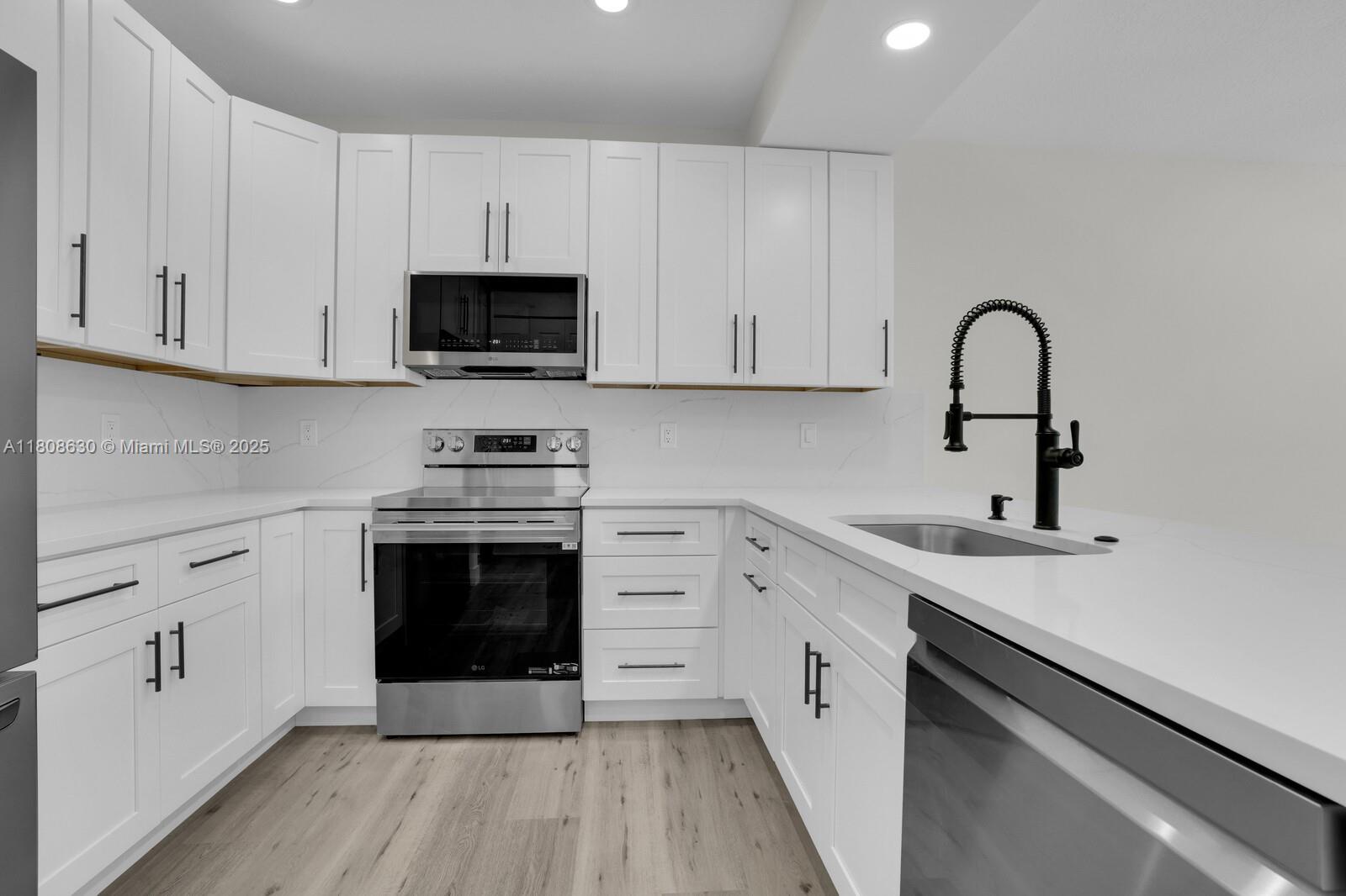 4123 Parkside Drive Jupiter, FL 33458 - Photo 5 of 39 a kitchen with stainless steel appliances granite countertop a stove a sink and a microwave