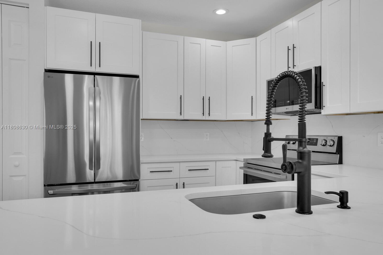 4123 Parkside Drive Jupiter, FL 33458 - Photo 6 of 39 a kitchen with stainless steel appliances white cabinets and a refrigerator