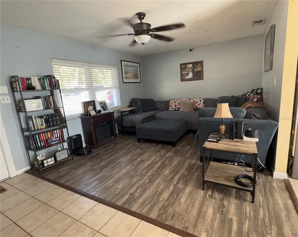 a living room with furniture and a book shelf