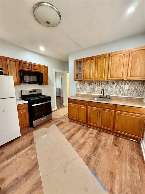 15 Dunlap Street, Unit 1 Boston, MA 02124 - Photo 1 of 8 a kitchen with stainless steel appliances granite countertop a sink and a stove