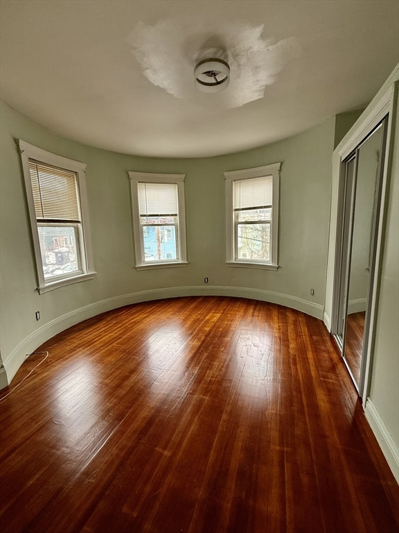 15 Dunlap Street, Unit 1 Boston, MA 02124 - Photo 3 of 8 an empty room with wooden floor and windows