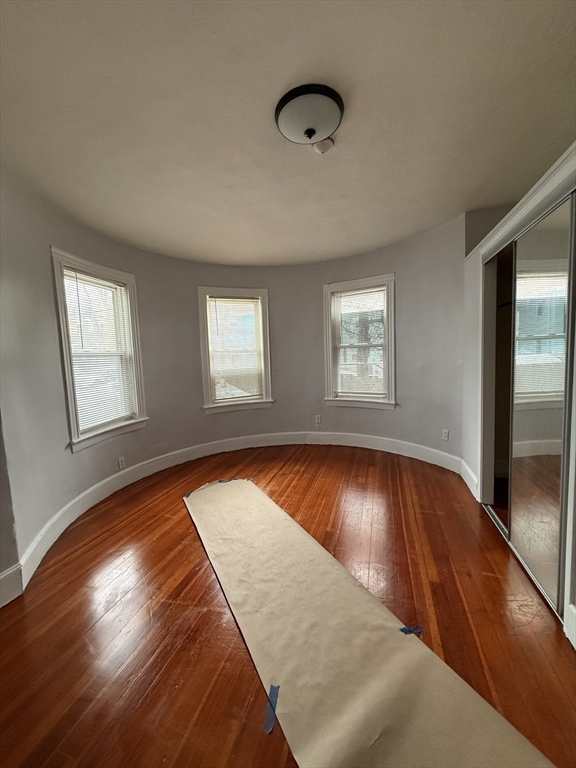 15 Dunlap Street, Unit 1 Boston, MA 02124 - Photo 7 of 8 an empty room with wooden floor and windows