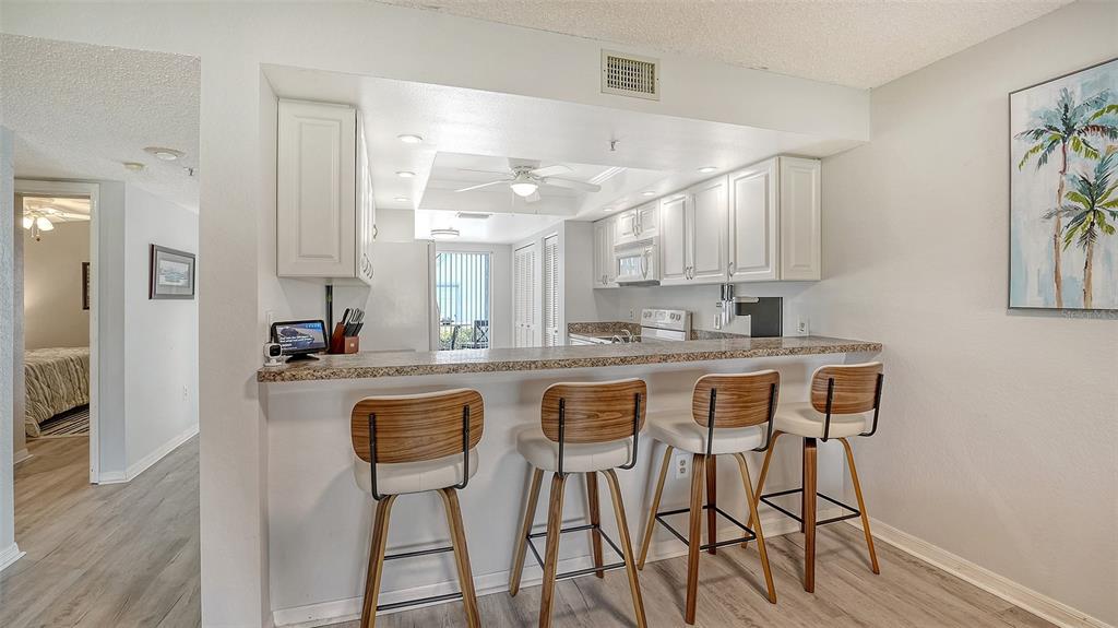 6611 Stone River Road, Unit 103 Bradenton, FL 34203 - Photo 11 of 61 a kitchen with stainless steel appliances granite countertop table chairs sink and cabinets