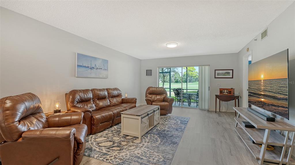 6611 Stone River Road, Unit 103 Bradenton, FL 34203 - Photo 13 of 61 a living room with furniture a flat screen tv and a window