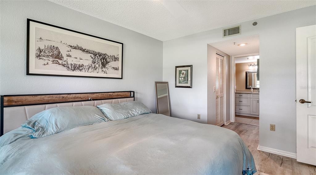 6611 Stone River Road, Unit 103 Bradenton, FL 34203 - Photo 22 of 61 a bedroom with a large bed and a painting on the wall