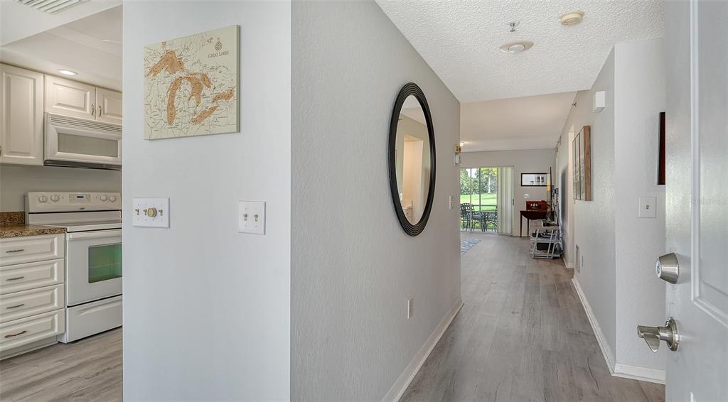 6611 Stone River Road, Unit 103 Bradenton, FL 34203 - Photo 6 of 61 a view of a hallway with wooden floor a fireplace and windows