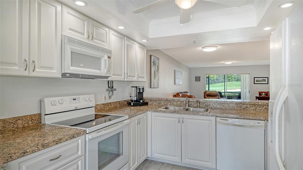 6611 Stone River Road, Unit 103 Bradenton, FL 34203 - Photo 9 of 61 a kitchen with stainless steel appliances granite countertop a sink stove and cabinets