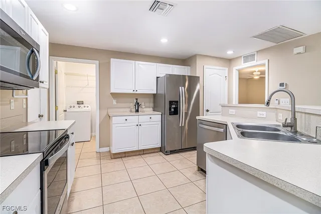 a kitchen with a sink appliances and cabinets