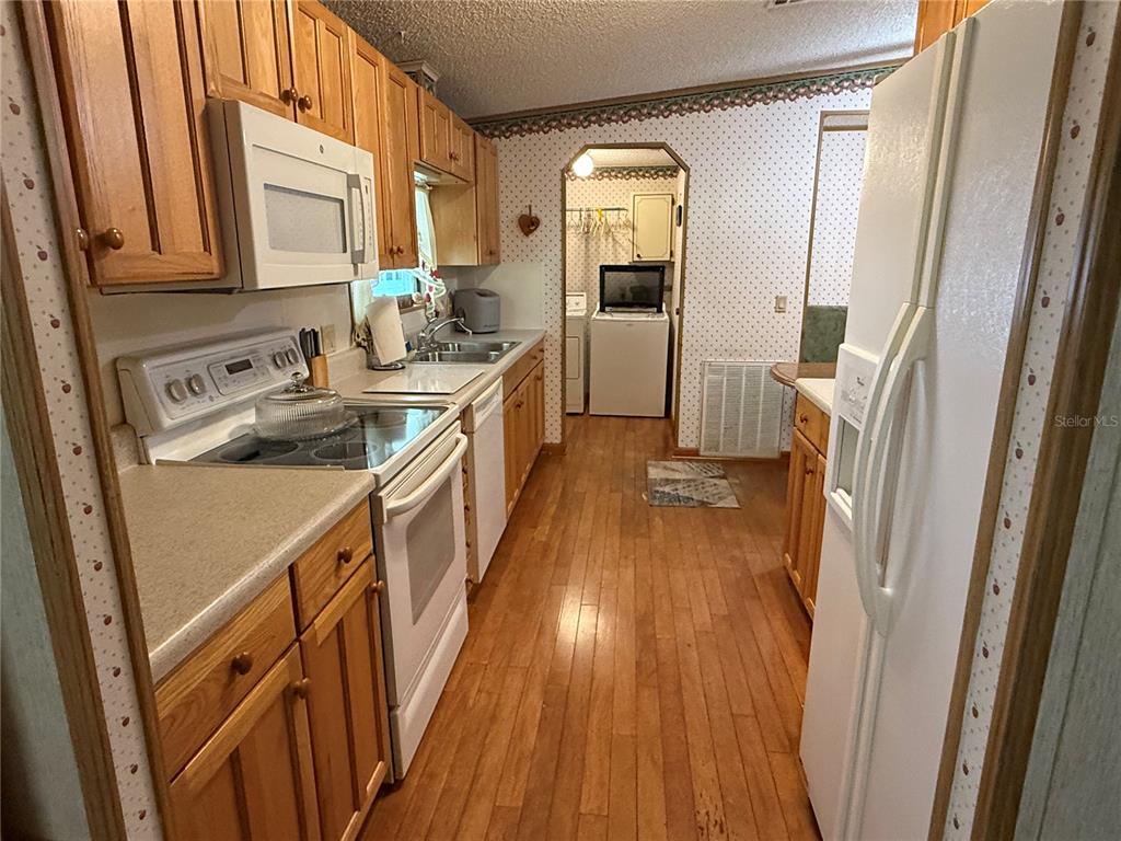 9300 Ottawa Street New Port Richey, FL 34654 - Photo 15 of 37 a kitchen with sink a refrigerator and wooden floor