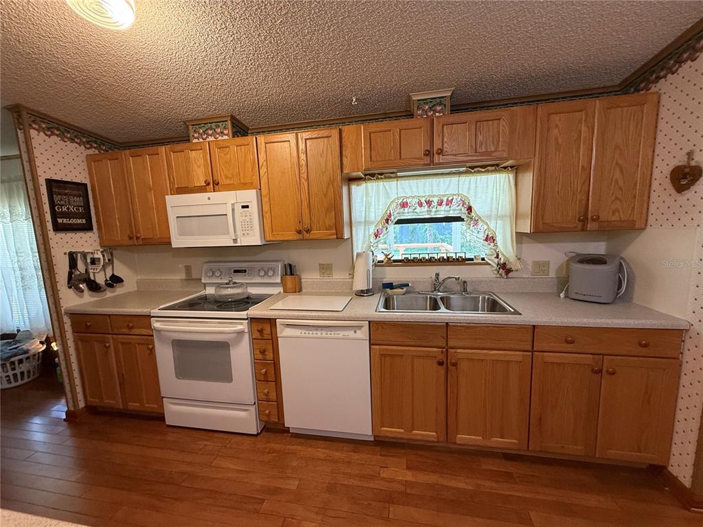 9300 Ottawa Street New Port Richey, FL 34654 - Photo 17 of 37 a kitchen with kitchen island granite countertop a sink cabinets and stainless steel appliances