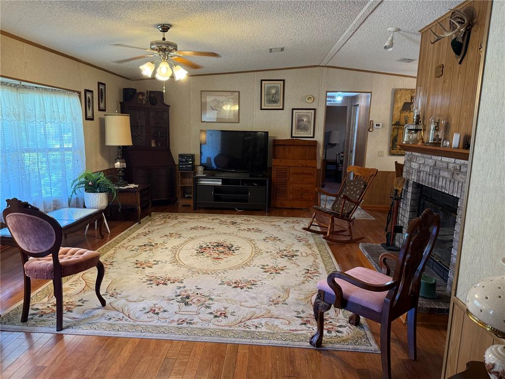 9300 Ottawa Street New Port Richey, FL 34654 - Photo 24 of 37 a living room with furniture a fireplace and a flat screen tv