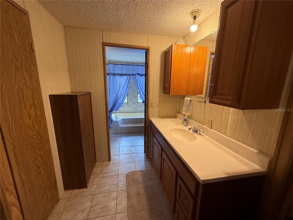 9300 Ottawa Street New Port Richey, FL 34654 - Photo 27 of 37 a bathroom with a sink a mirror and a vanity