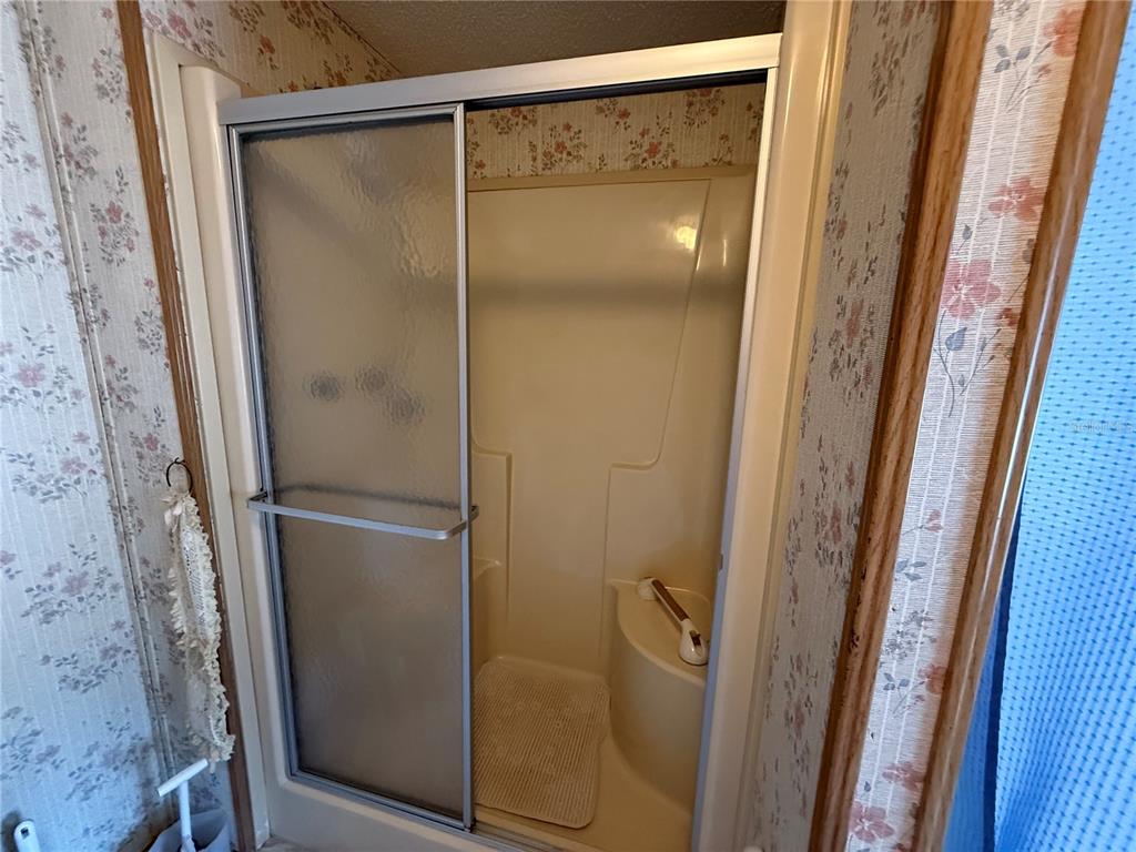 9300 Ottawa Street New Port Richey, FL 34654 - Photo 29 of 37 a bathroom with a glass shower door