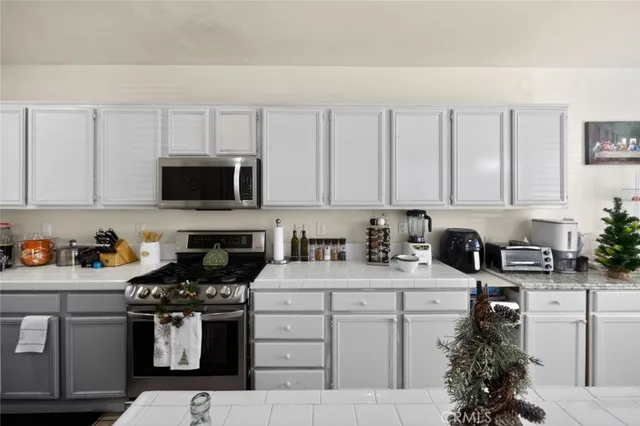 a kitchen with appliances a sink and cabinets