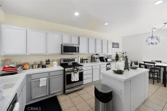 a kitchen with a sink dishwasher stove and white cabinets