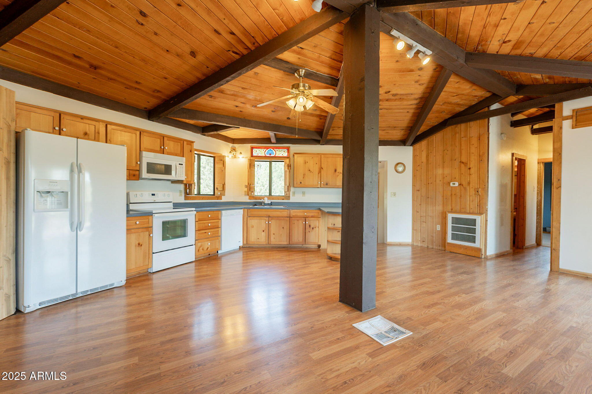 3524 Kelly Circle Pine, AZ 85544 - Photo 14 of 69 a view of an empty room with wooden floor and a kitchen