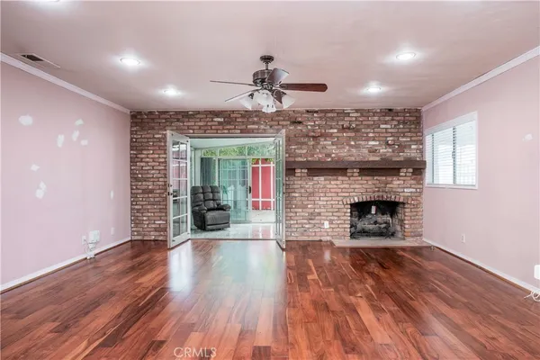 a view of a livingroom with fireplace wooden floor and a window