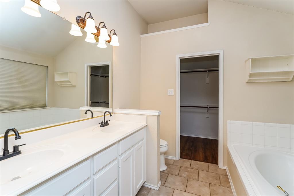10706 Robincreek Lane Frisco, TX 75035 - Photo 11 of 17 Full bathroom with a bath, a walk in closet, double vanity, lofted ceiling, and light tile patterned floors