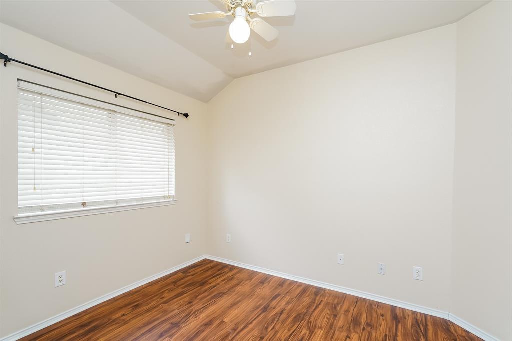 10706 Robincreek Lane Frisco, TX 75035 - Photo 12 of 17 Unfurnished room with wood finished floors, lofted ceiling, and ceiling fan
