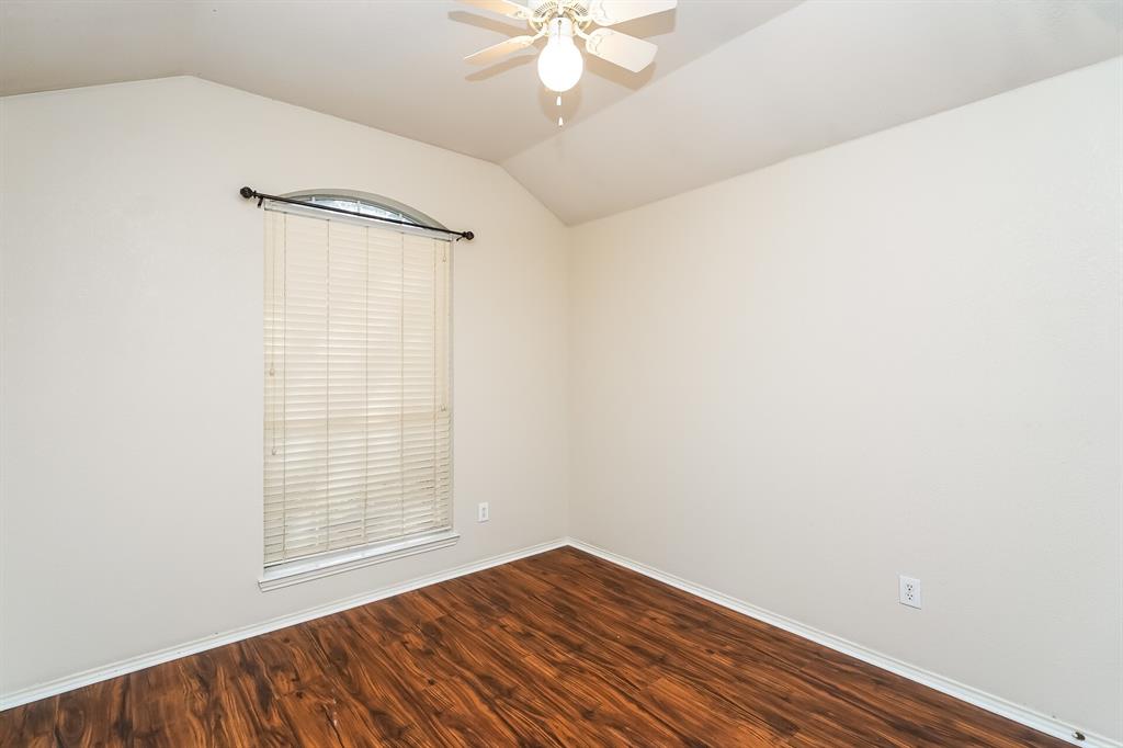 10706 Robincreek Lane Frisco, TX 75035 - Photo 13 of 17 Spare room with dark wood-style flooring, lofted ceiling, and a ceiling fan
