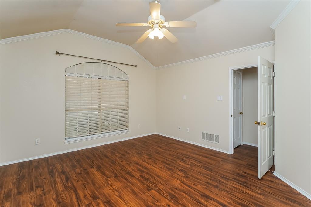 10706 Robincreek Lane Frisco, TX 75035 - Photo 9 of 17 Empty room with lofted ceiling, dark wood-style flooring, crown molding, and a ceiling fan