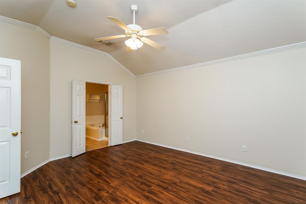 10706 Robincreek Lane Frisco, TX 75035 - Photo 10 of 17 Unfurnished bedroom featuring vaulted ceiling, ornamental molding, dark wood-style flooring, a ceiling fan, and connected bathroom