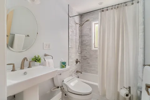 a bathroom with a sink a toilet and shower curtain