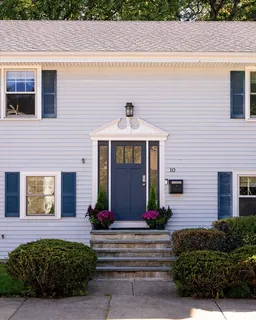 a front view of a house with potted plants