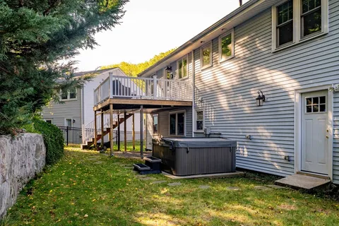 a view of an house with backyard and a tree