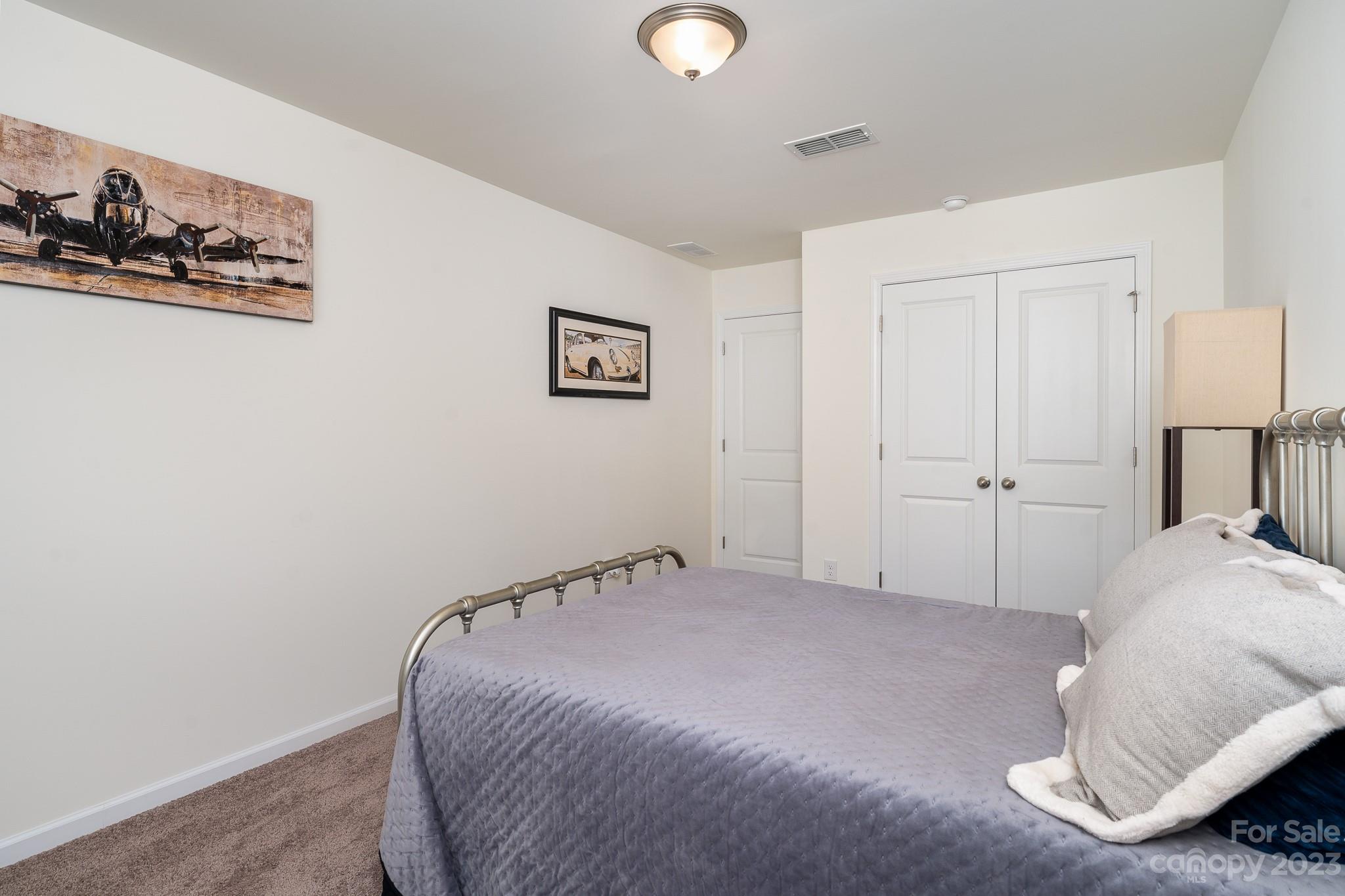 229 Quinn Road Matthews, NC 28104 - Photo 16 of 23 a bedroom with a bed and a wall painting