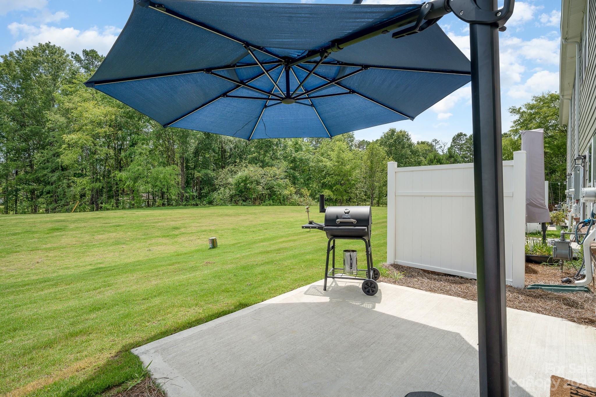 229 Quinn Road Matthews, NC 28104 - Photo 23 of 23 a view of a chair and table under an umbrella