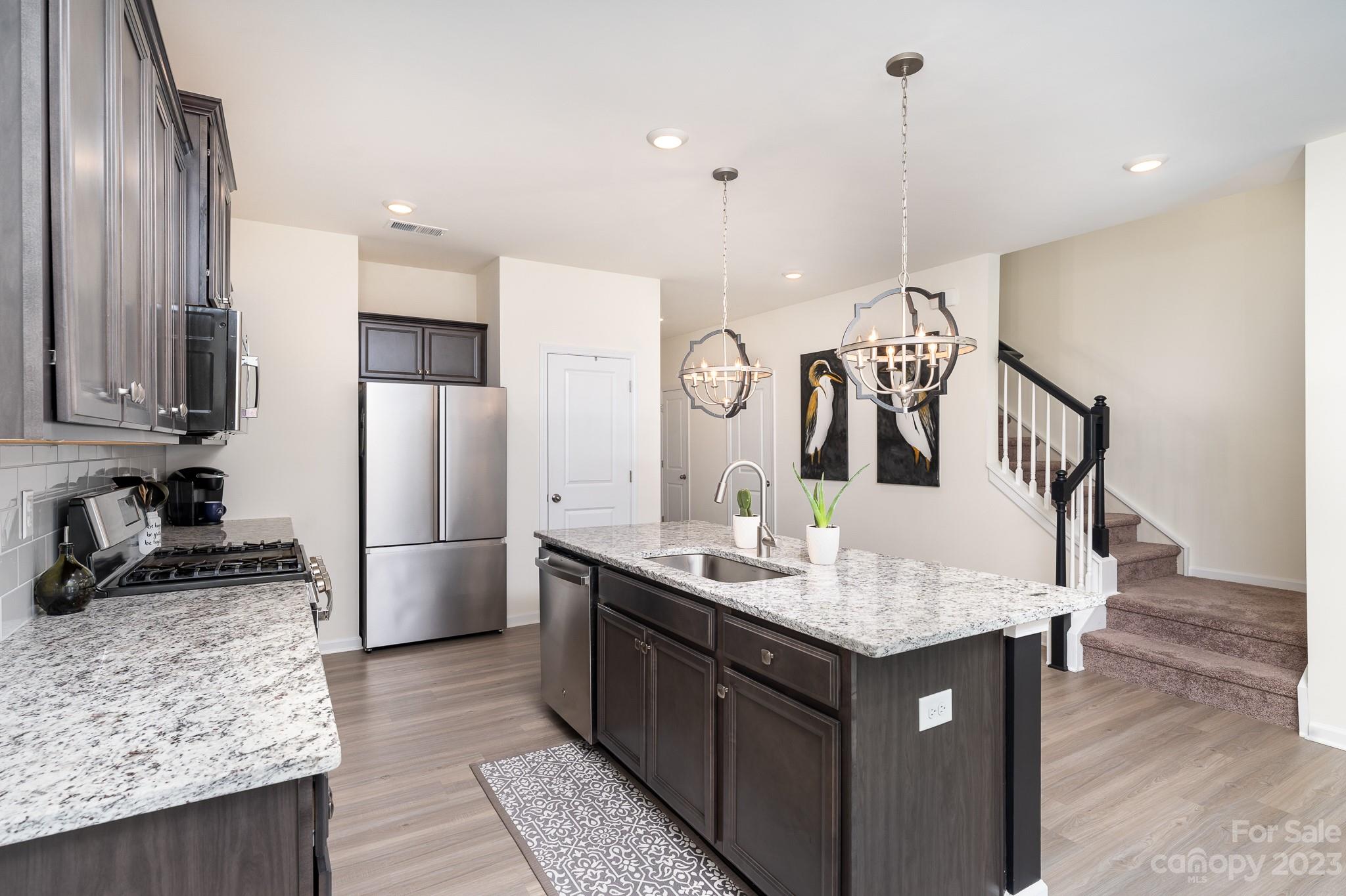 229 Quinn Road Matthews, NC 28104 - Photo 6 of 23 a kitchen with kitchen island granite countertop a sink a counter and stainless steel appliances