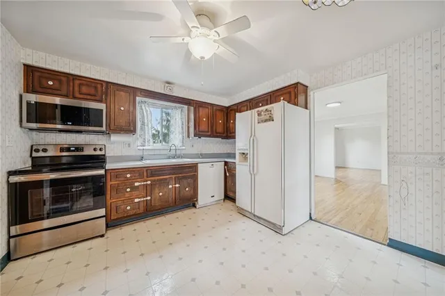 a kitchen with stainless steel appliances granite countertop a refrigerator oven a sink and dishwasher