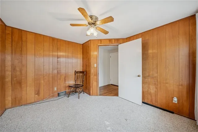 a view of a room with a large window and a ceiling fan
