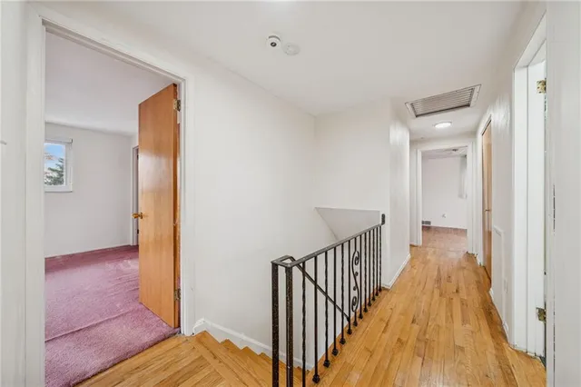a view of a hallway with wooden floor and closet