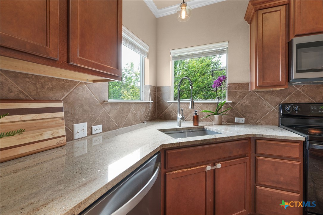 408 Copper Ridge Loop Temple, TX 76502 - Photo 16 of 39 Bright kitchen workspace with ample counter space and large windows providing views of the backyard