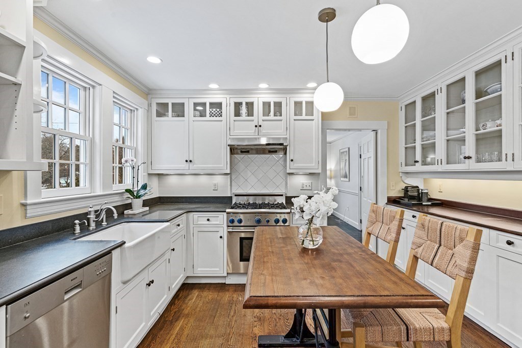 35 Sawyer Road Wellesley, MA 02481 - Photo 6 of 27 a kitchen with stainless steel appliances granite countertop a stove a sink dishwasher a dining table and chairs with wooden floor