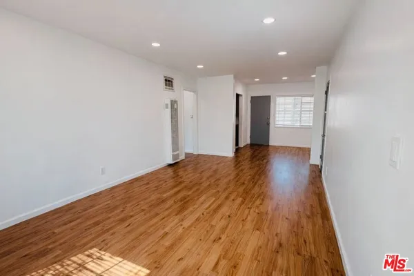 a view of a big room with wooden floor and natural light