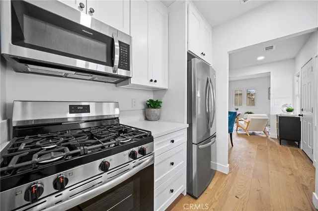 a kitchen with stainless steel appliances a stove a microwave and cabinets