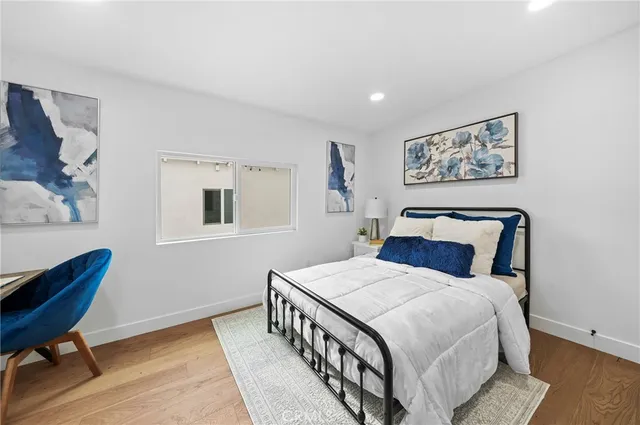 a bedroom with a bed a painting on the wall and a window