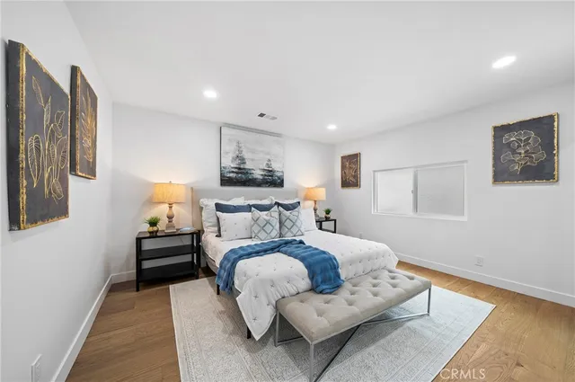 a bedroom with a bed and wooden floor