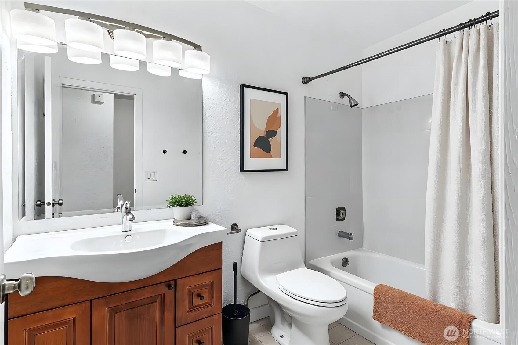 5832 Northeast 75th Street, Unit E304 Seattle, WA 98115 - Photo 22 of 36 a bathroom with a sink toilet a mirror a vanity and shower