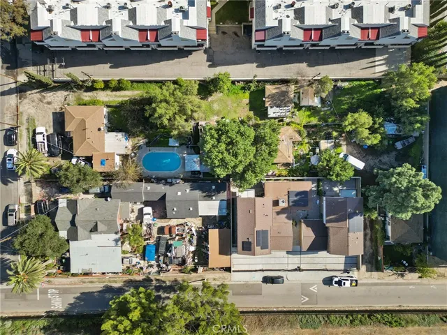 an aerial view of residential houses with outdoor space and swimming pool
