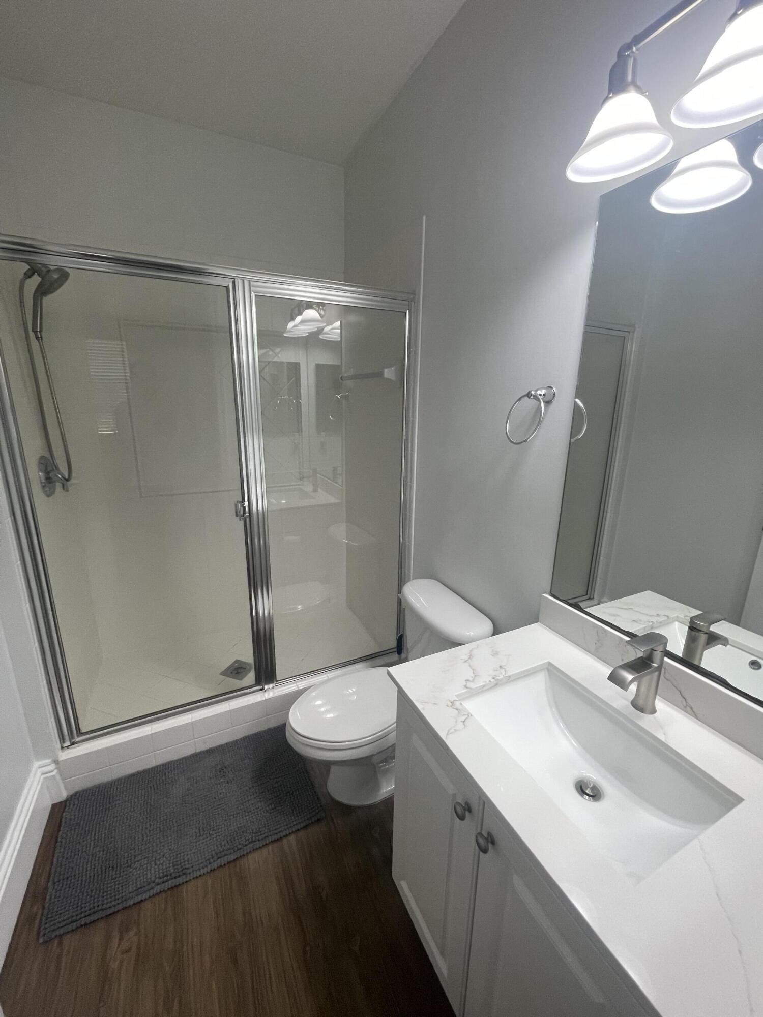 111 Stone Harbor Way, Unit F2 Delray Beach, FL 33444 - Photo 11 of 11 a bathroom with a sink toilet a mirror and shower