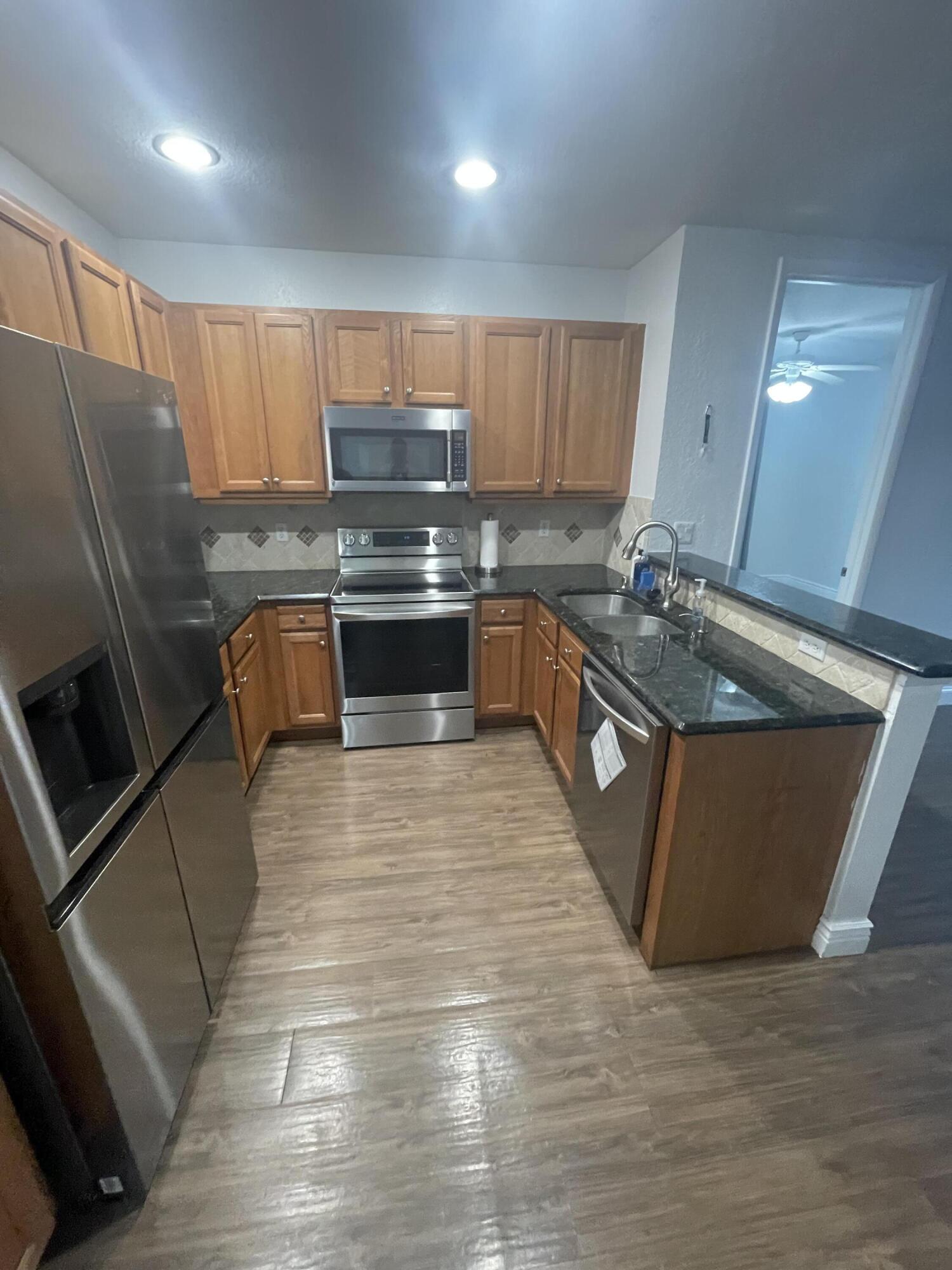 111 Stone Harbor Way, Unit F2 Delray Beach, FL 33444 - Photo 6 of 11 a kitchen with stainless steel appliances granite countertop a sink a stove and a refrigerator
