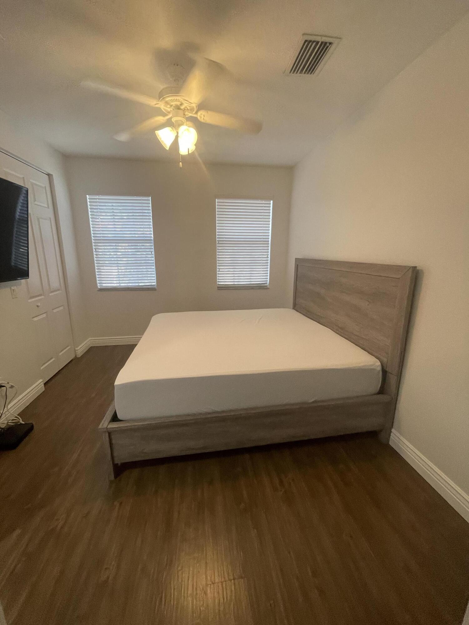 111 Stone Harbor Way, Unit F2 Delray Beach, FL 33444 - Photo 10 of 11 a spacious bedroom with a bed and wooden floor