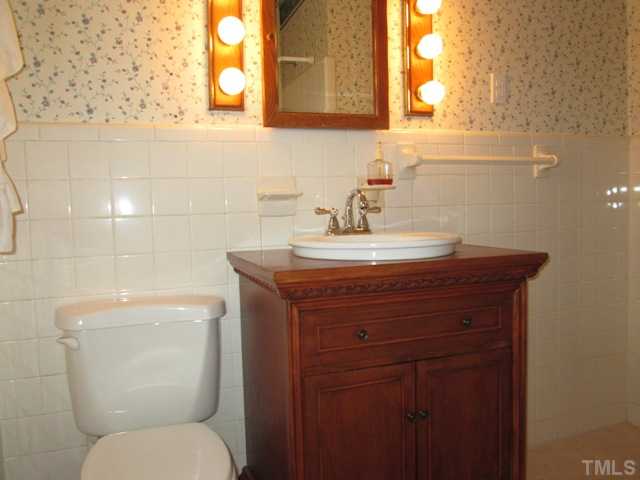 1408 Southerlund Road Garner, NC 27529 - Photo 23 of 25 Full bath features updated plumbing fixtures in bath tub! All new tile floor, tile walls, custom furniture style vanity & elongated toilet!