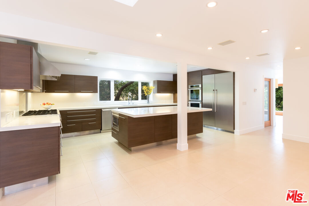 28929 Wight Road Malibu, CA 90265 - Photo 7 of 22 a large kitchen with stainless steel appliances a large counter top a stove and a refrigerator