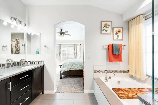 a bathroom with a tub sink and mirror